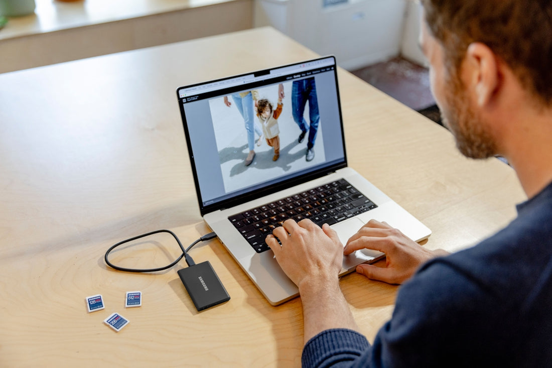 A man sitting at a table using a laptop computer