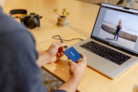 A man sitting at a table with a laptop and a cell phone