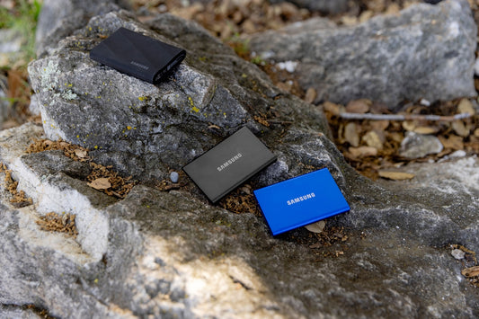A couple of cell phones sitting on top of a rock